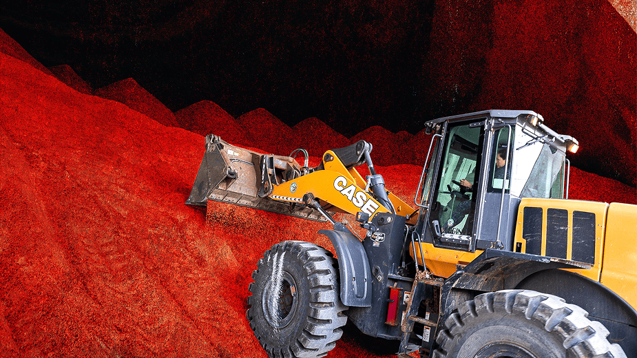 A front-loader scoops up salt from a large pile.