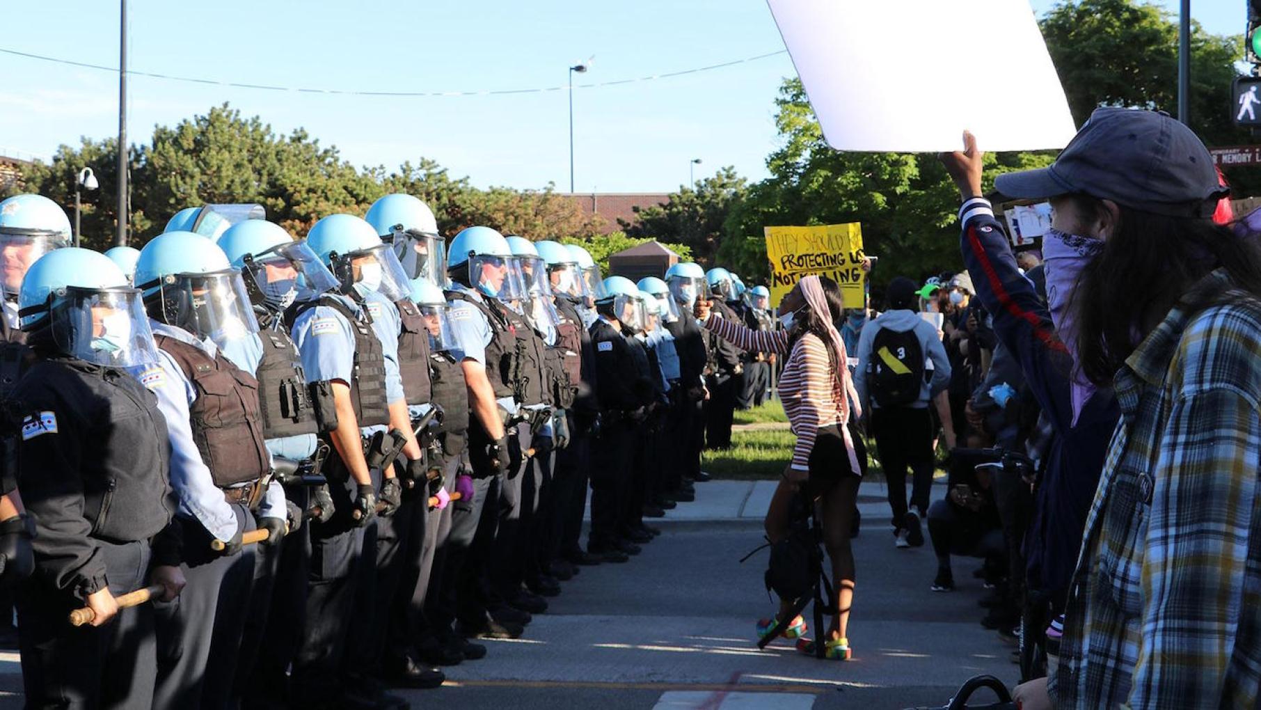 Protesters confront a line of police officers at State and 35th streets, about 3 miles south of the Loop, where police set up a blockade. (Evan Garcia / WTTW News)